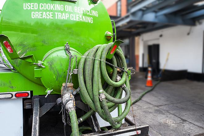 a technician pumping a grease trap in a commercial building in Lennox CA